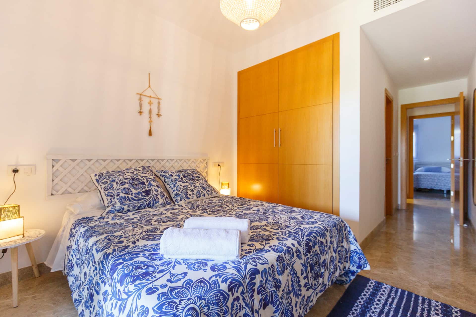 Dormitorio principal con armario en madera clara y acceso al pasillo del apartamento.