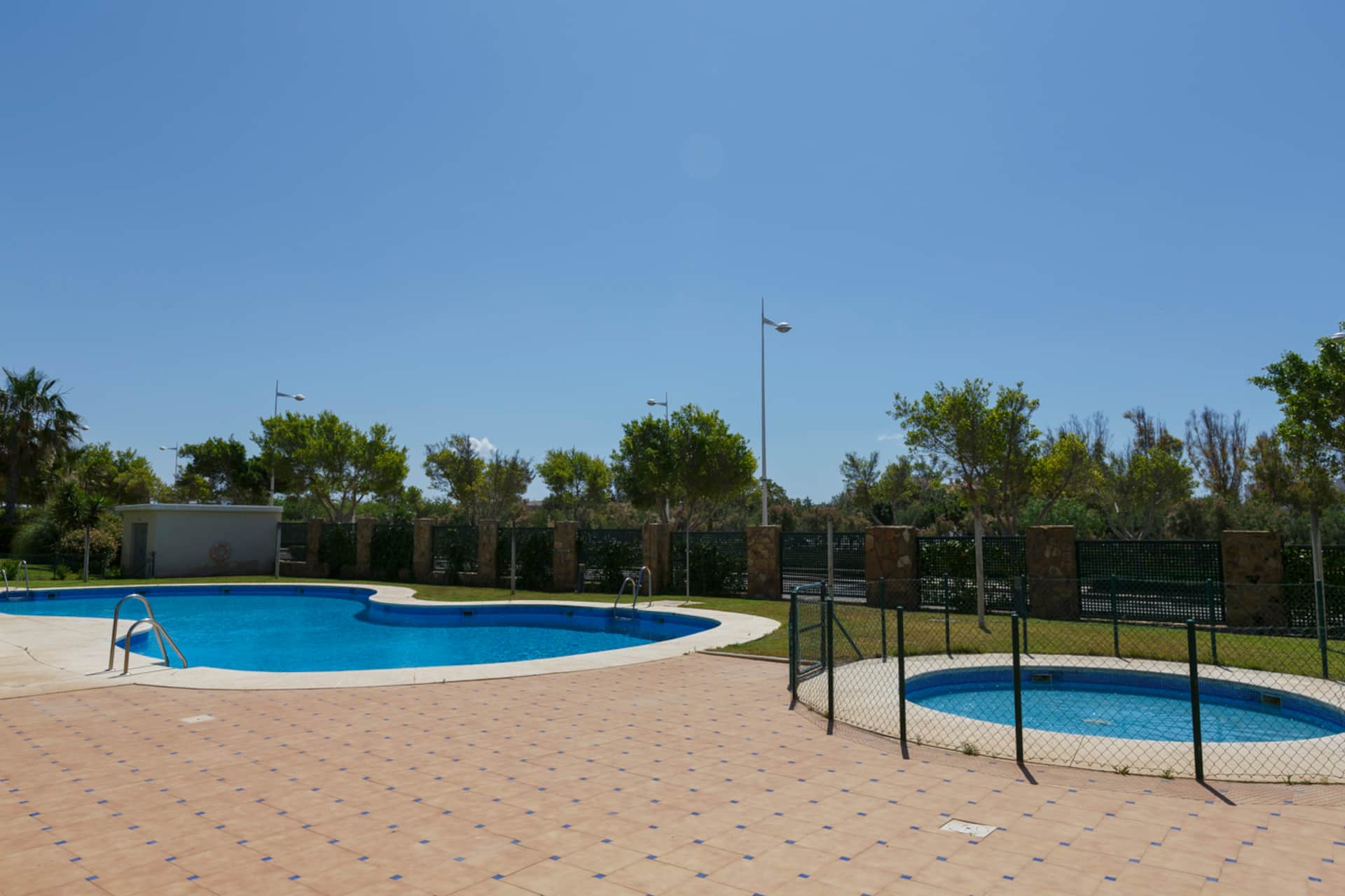 Piscina comunitaria con vaso infantil independiente y vallado de seguridad.