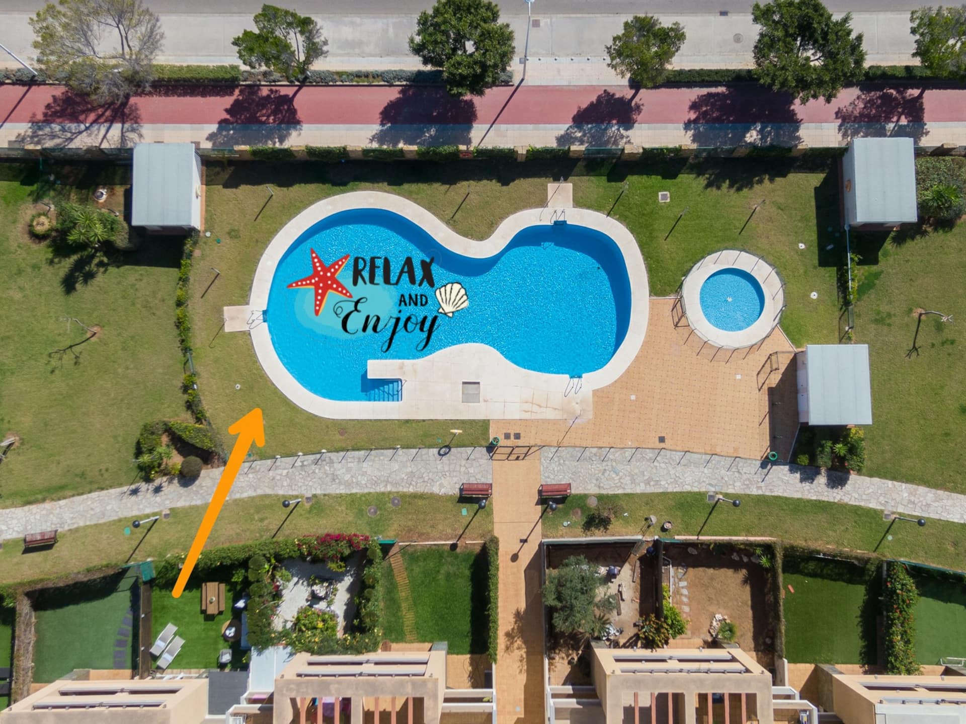 Vista aérea de la piscina comunitaria y el jardín del edificio.