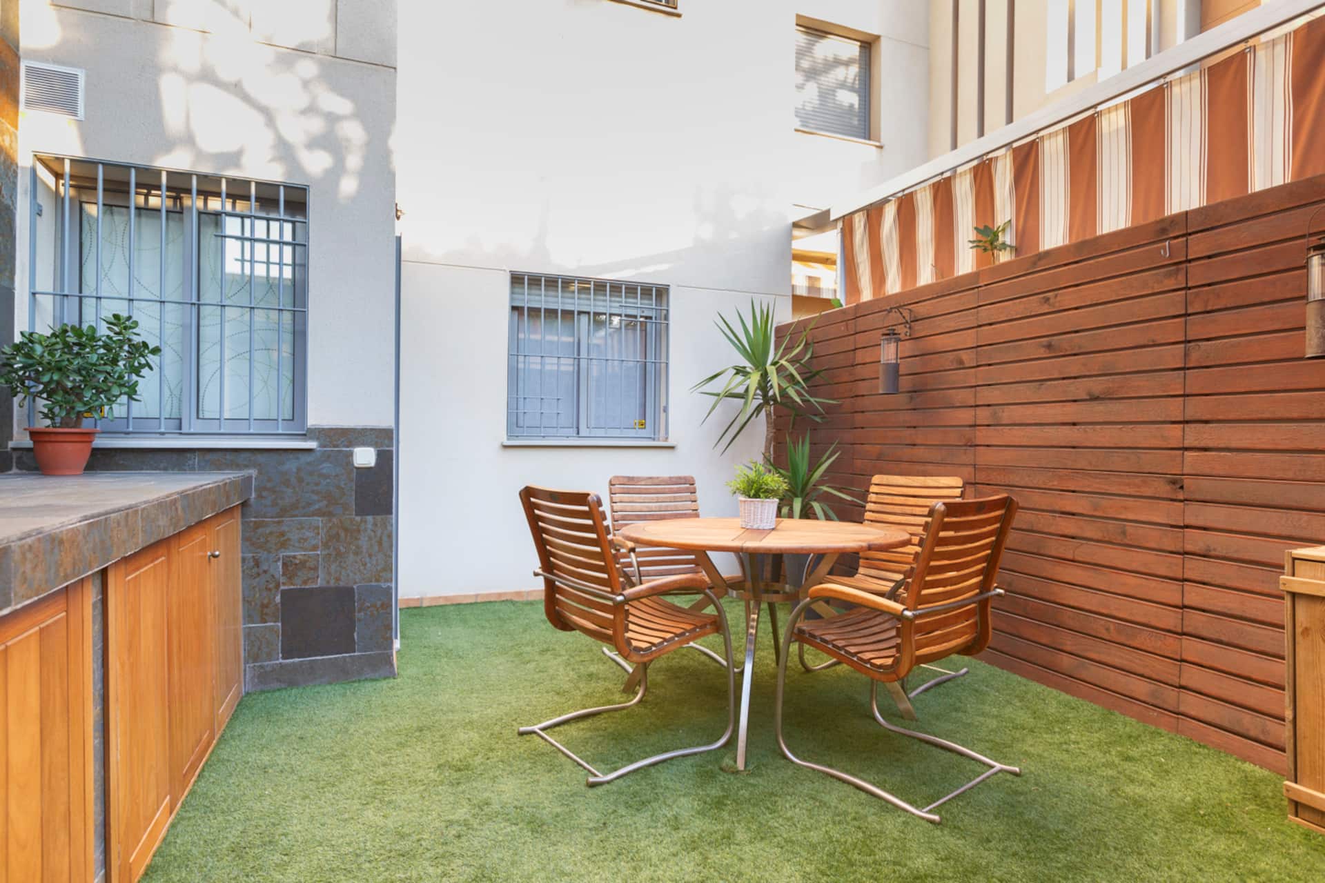 Patio trasero con mesa auxiliar junto a la zona de cocina de la terraza.