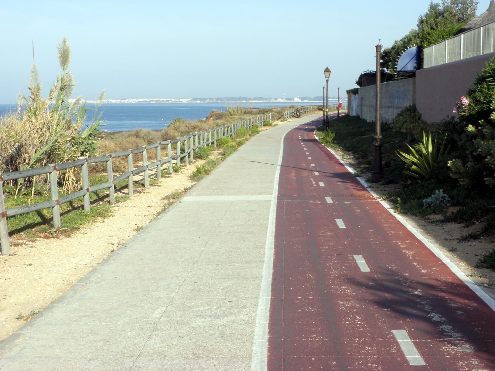 Carril bici junto al paseo marítimo, con el mar al fondo, en la costa andaluza.