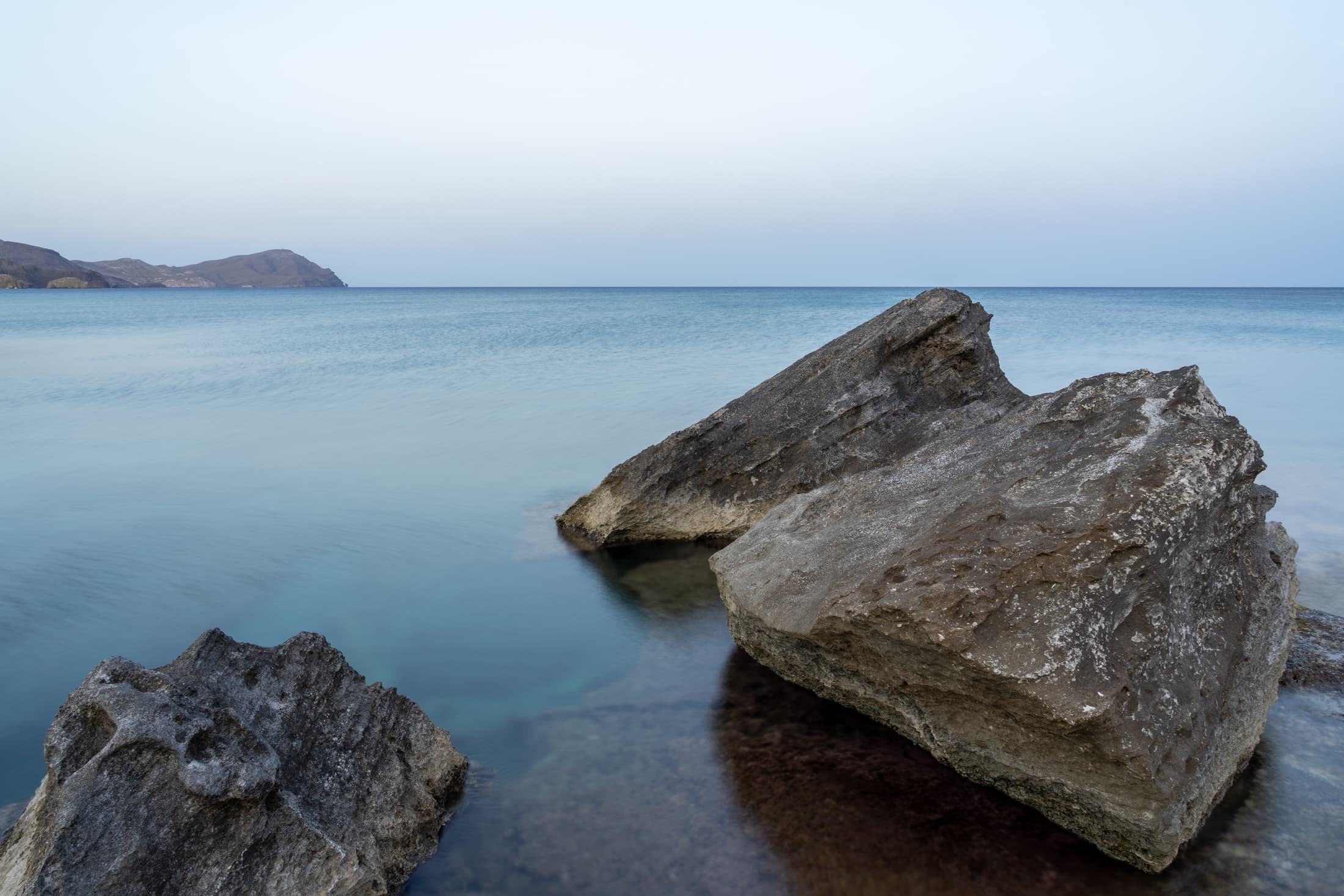 Grandes rocas junto a un mar en calma en la costa de Cabo de Gata.