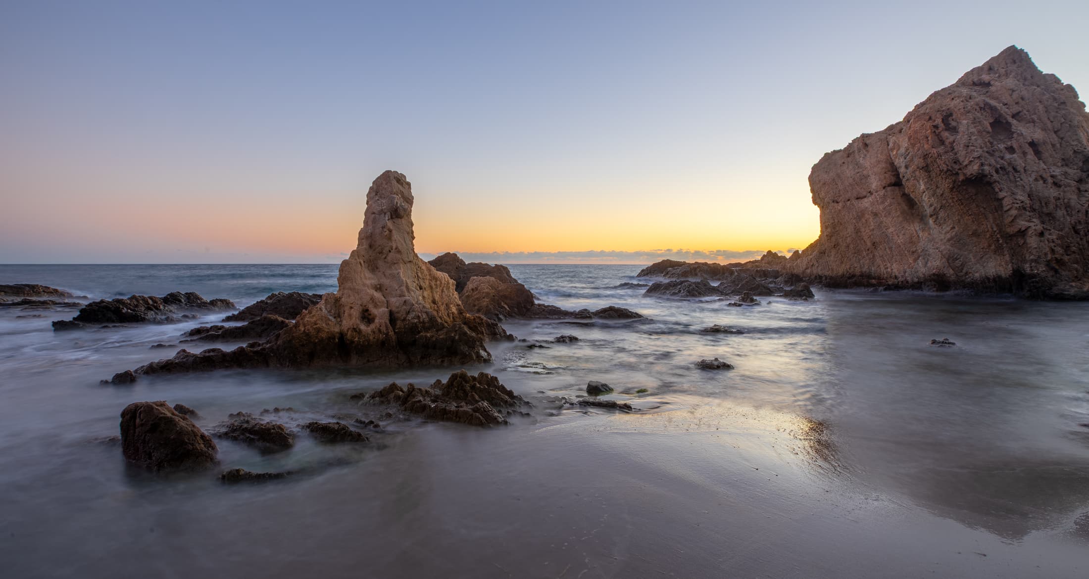 Formaciones rocosas junto al mar al atardecer en Cabo de Gata.