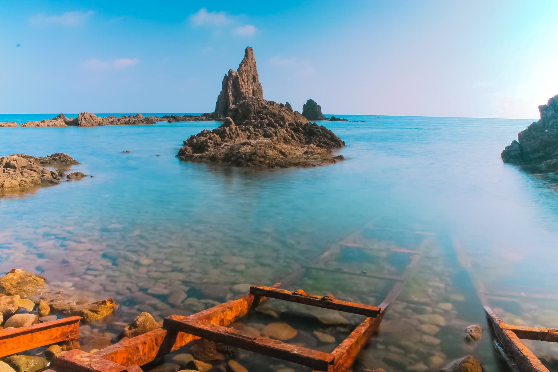 El Arrecife de las Sirenas, en Cabo de Gata, con aguas turquesas y formaciones rocosas volcánicas.
